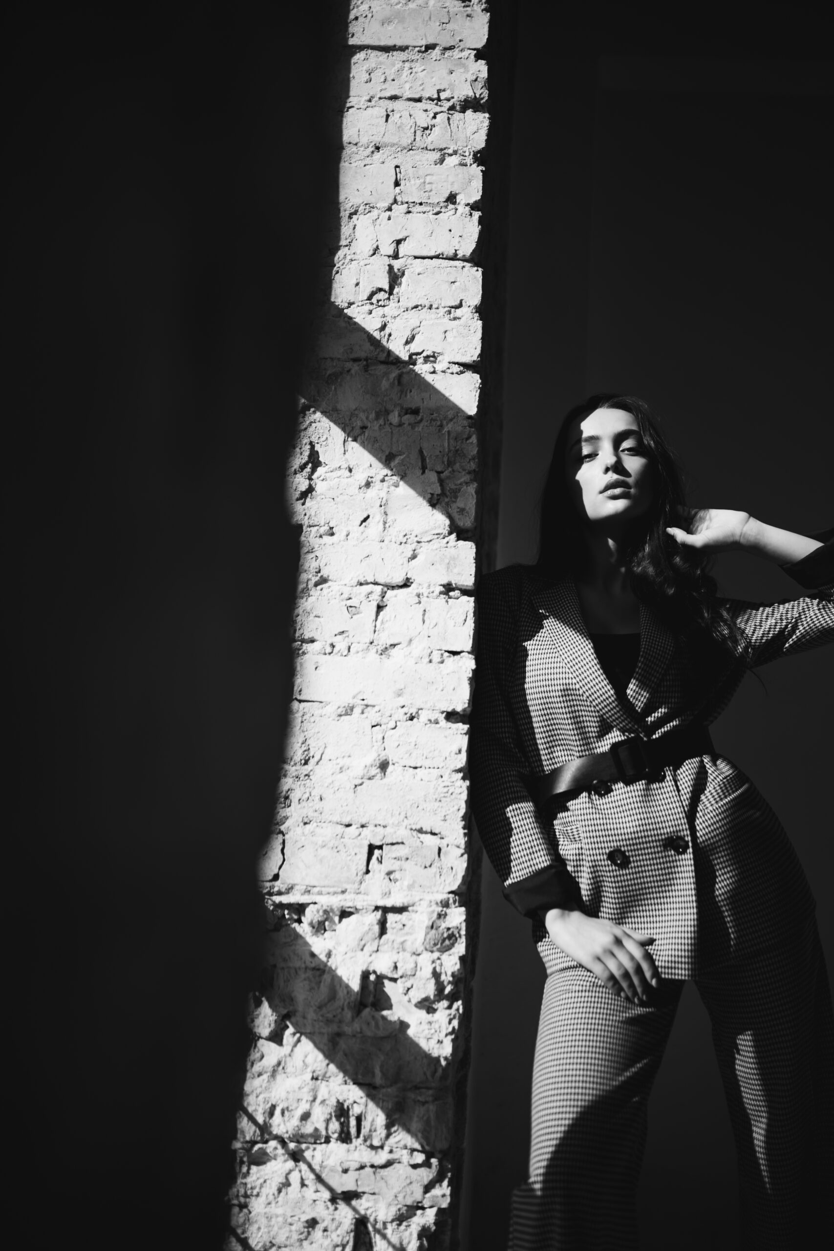 Woman in a business suit by the brick wall